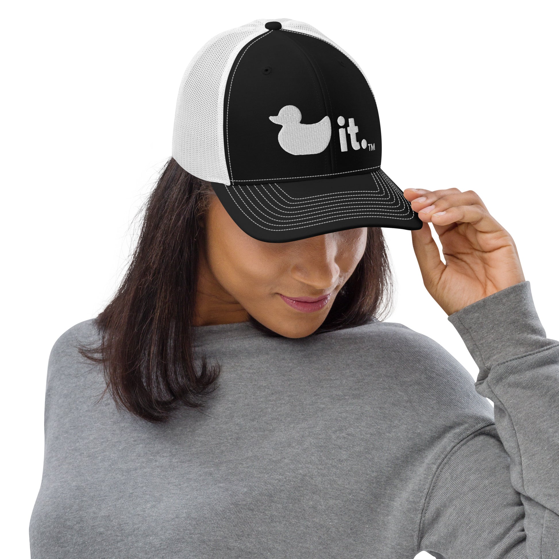 Duck it logo black and white trucker hat female model